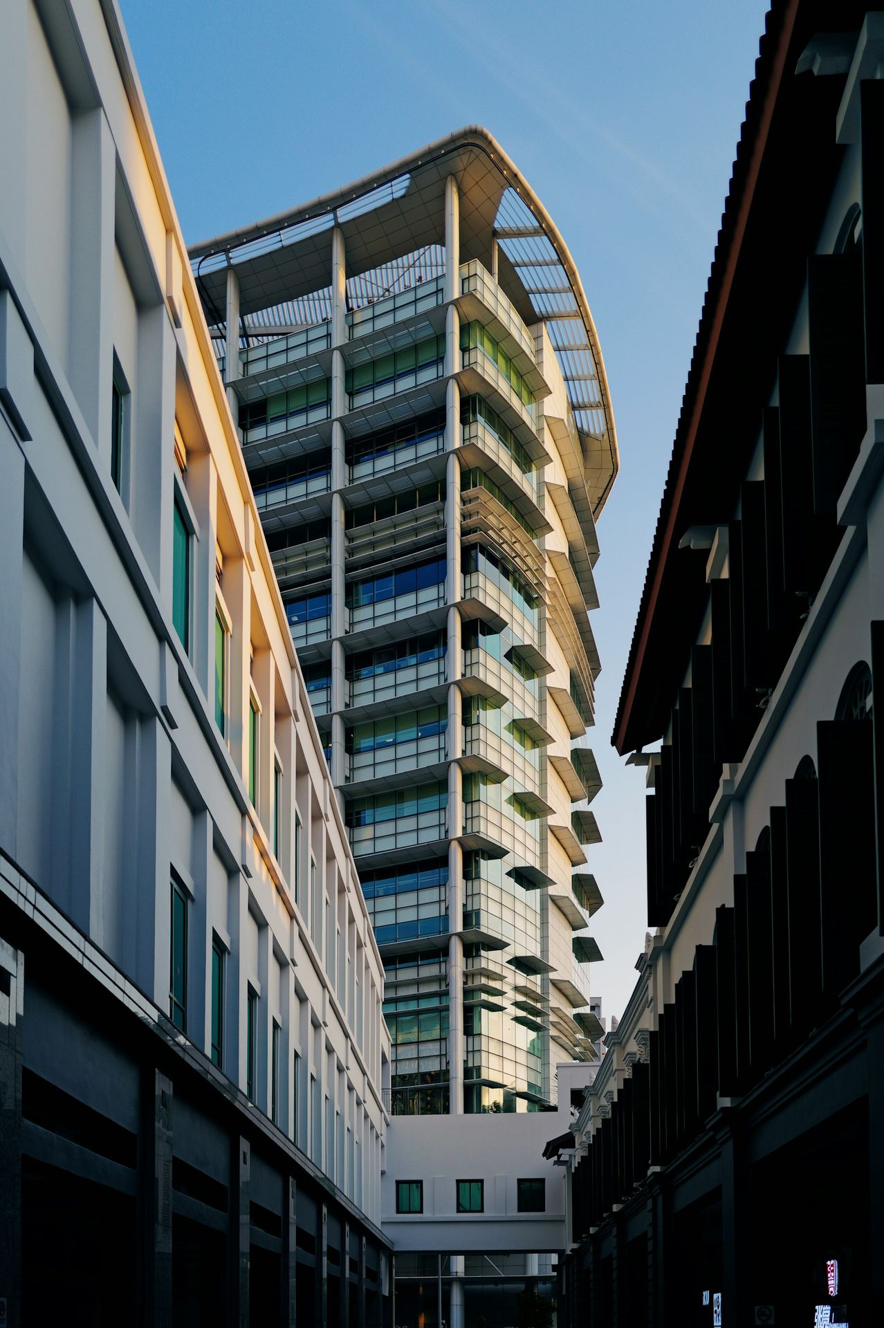 A tall building sitting next to a couple of buildings